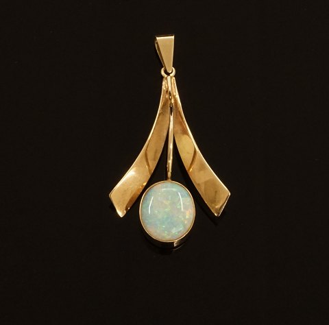 A 14kt gold pendant with an opal. Size: 4,5x2,3cm