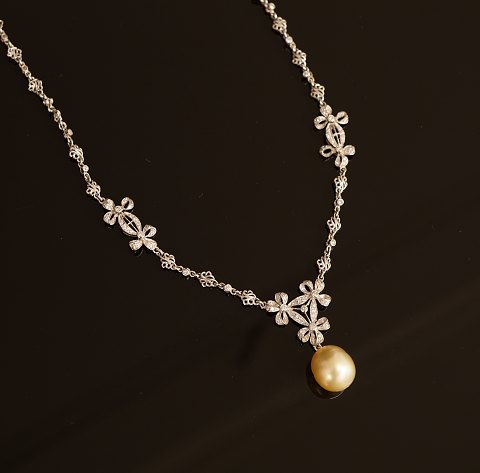 Halskæde i 18kt hvidguld besat med talrige diamanter og perle. L: 42cm
