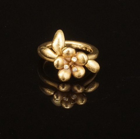 Ole Lynggaard: Blomst ring i 18kt guld prydet med tre diamanten på i alt ca. 0,03ct. Ringstr. 54. Leveres med original etui og æske