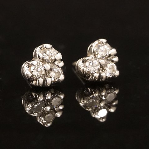 Et par hjerteformede 14kt hvidguldsørestikker med tre diamanter i hver. I alt ca. 0,6ct. Låse 8kt hvidguld