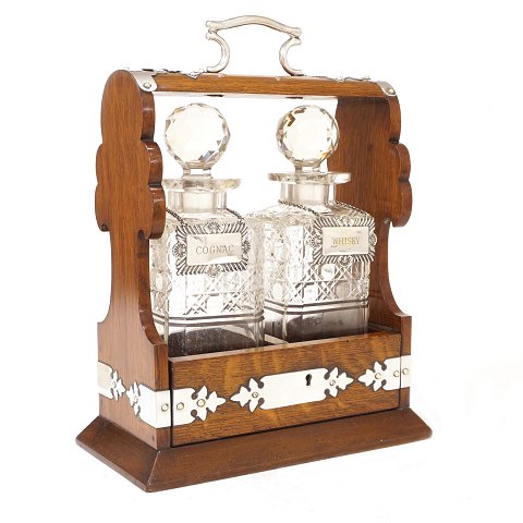 Tantalus in an oak box with two decanters. England circa 1880. H: 33cm. W: 25cm. D: 14cm