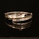 A 14kt gold and sterlingsilver bangle with two diamonds of ca. 0,08ct. Size: 6,6x6cm