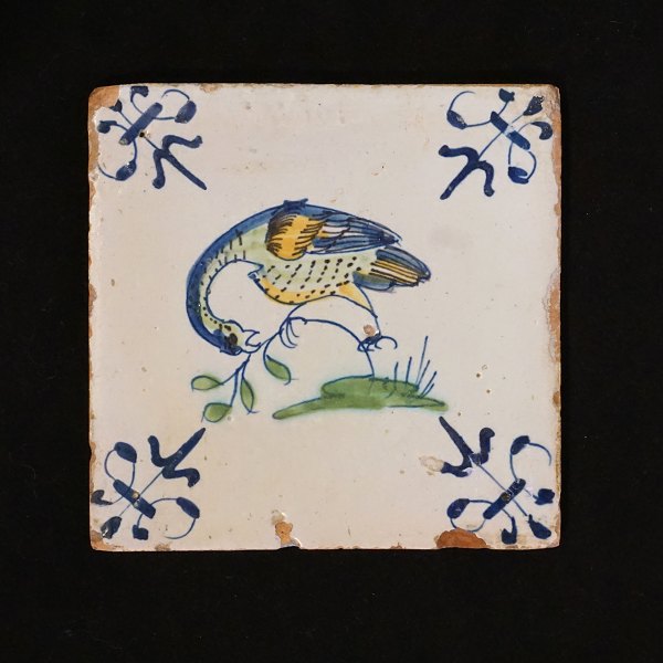 Polykrom dekoreret hollandsk flise med fuglemotiv. Cirka år 1620-40. Mål: 13x13cm