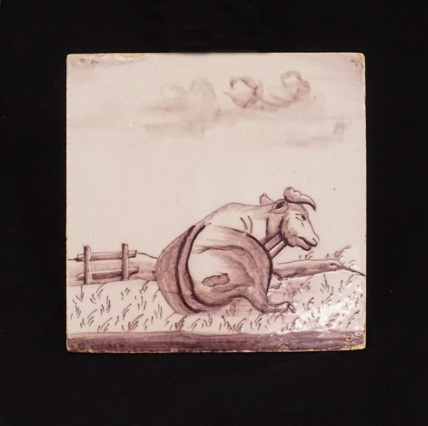Mangan dekoreret flise med motiv i form af en ko. Holland ca. år 1800. Mål: 13x13cm