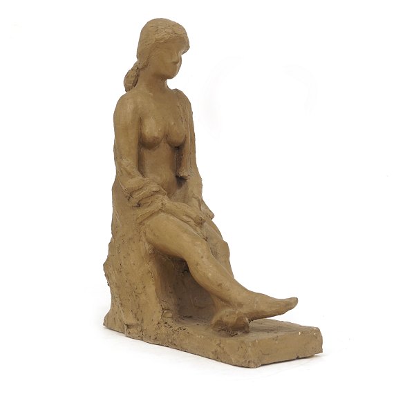 Skulptur in Form von einer sitzenden Frau. Signiert "ML 60". H: 28cm. B: 11cm. 
L: 21cm