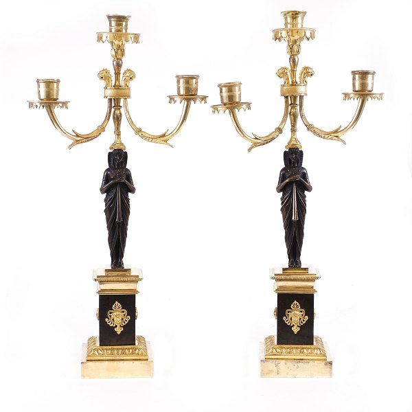 Et par store lueforgyldte empire bronzekandelabre, delvist sortpatinerede, til tre lys. Frankrig ca. år 1820. H: 51cm